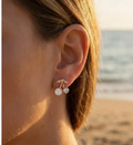 Boucles d'oreilles cerises avec perle nacrée et strass portées sur plage