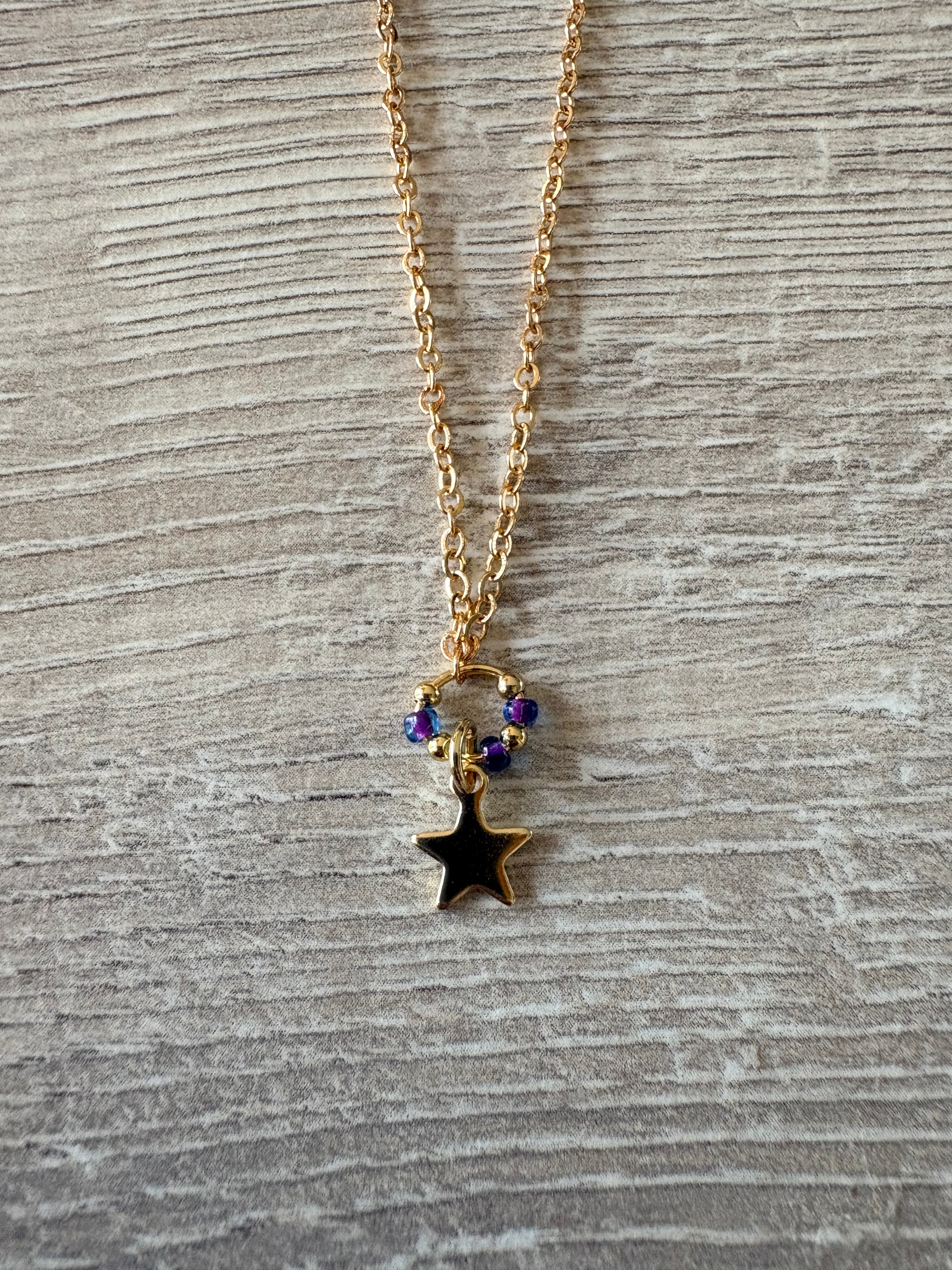 Collier chaîne dorée avec pendentif étoile noire et perles violettes irisées